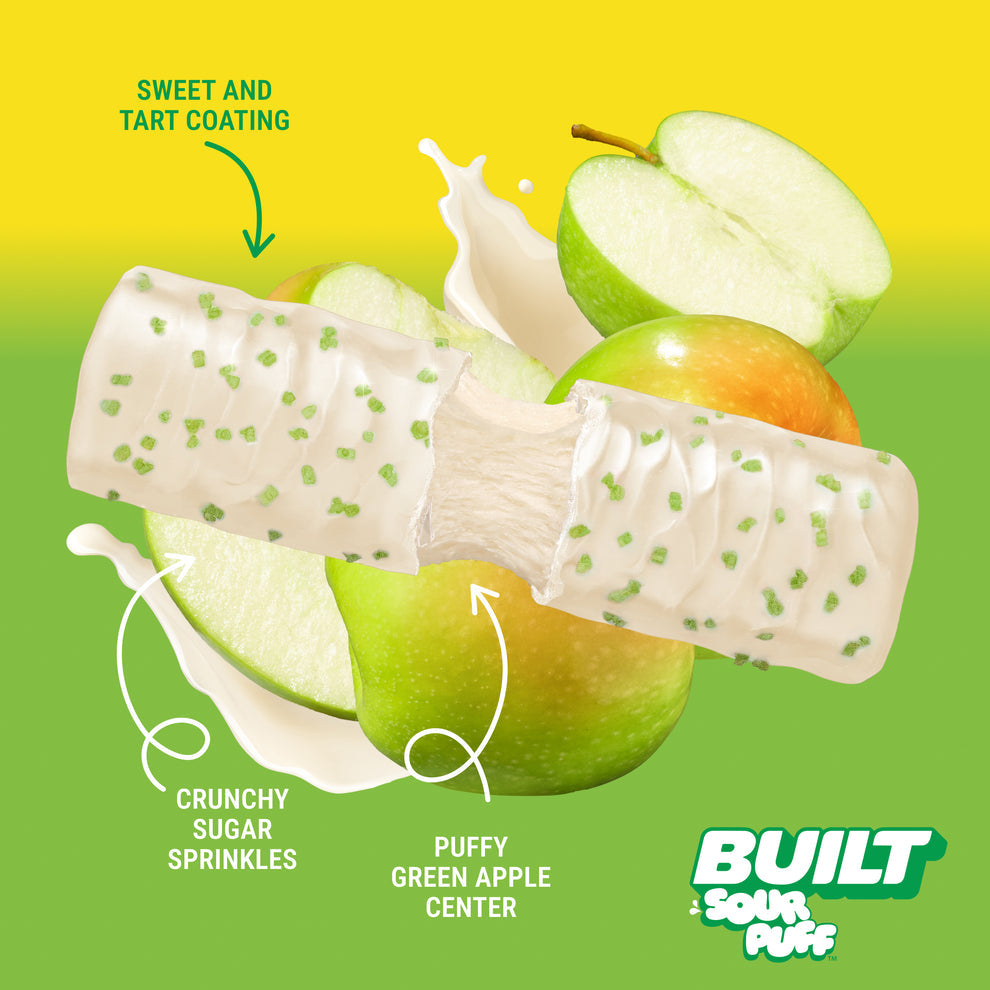 Built Bar Puffs Canada – Sour Puff Green Apple Crush Protein Bar 40g partially unwrapped showing white chocolate coating with crunchy sugar sprinkles and puffy green apple center on green background