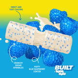 Built Bar Puffs Canada – Sour Puff Blue Razz Protein Bar 40g partially unwrapped showing white chocolate coating with crunchy sugar sprinkles and puffy blue raspberry center on blue and green background