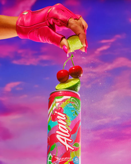 Colorful soda can with cherry and lime garnish against a vibrant purple sky.