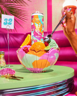 Colorful bowl of ice cream with a can of Fanta cocktail and a hand holding a spoon.