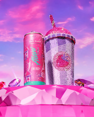 Pink energy drink can and sparkly tumbler with unicorn design against a colorful sky.